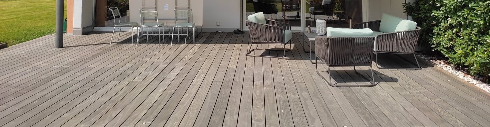Terrasse mit grauem Holzdeck und Gartenmöbeln