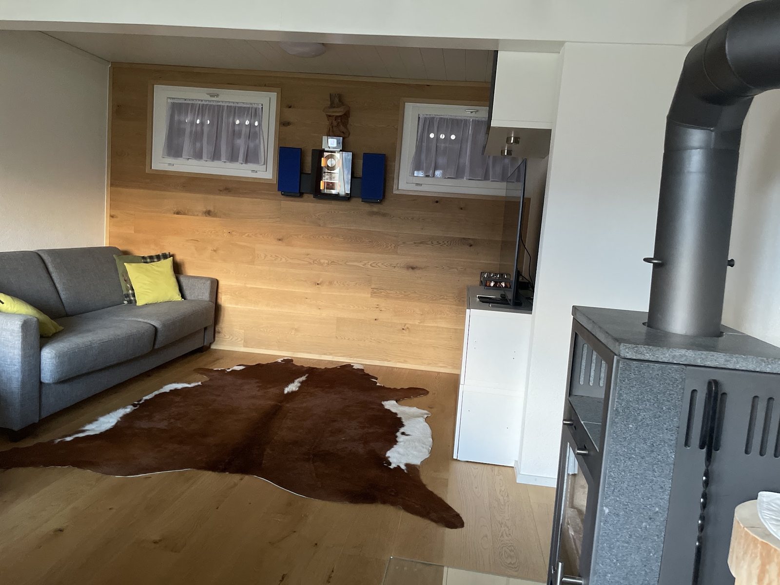 Wohnzimmer mit Eichenboden und Eichenwand, daneben ein Holzofen